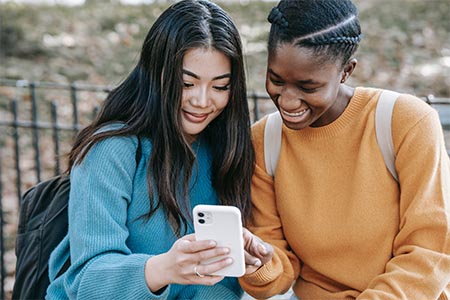 2 young women looking at phone zelle