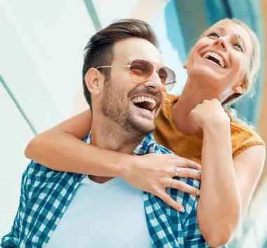 a man holding a woman on his shoulders.
